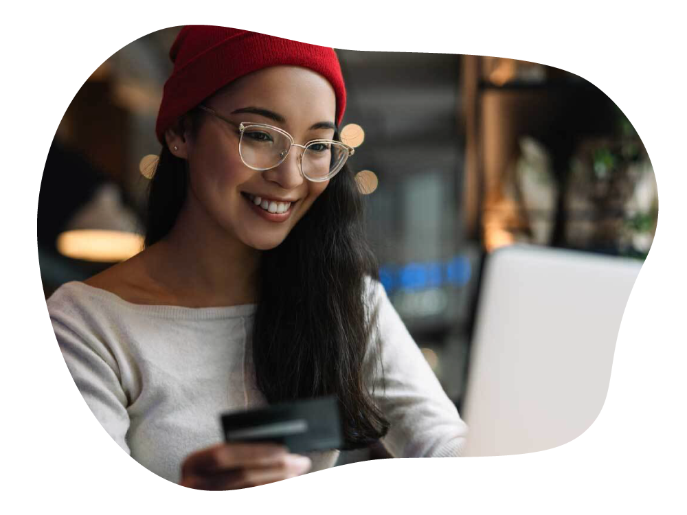 Lady happily making online payment on laptop, with credit card